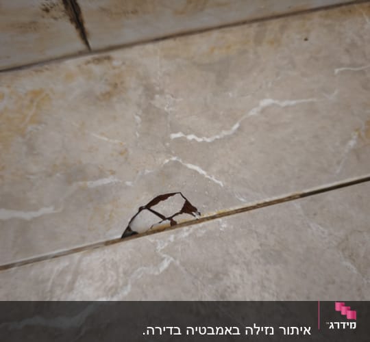 אריח שבור עם סימני רטיבות על הקיר
